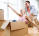 couple with cardboard boxes having fun at new home