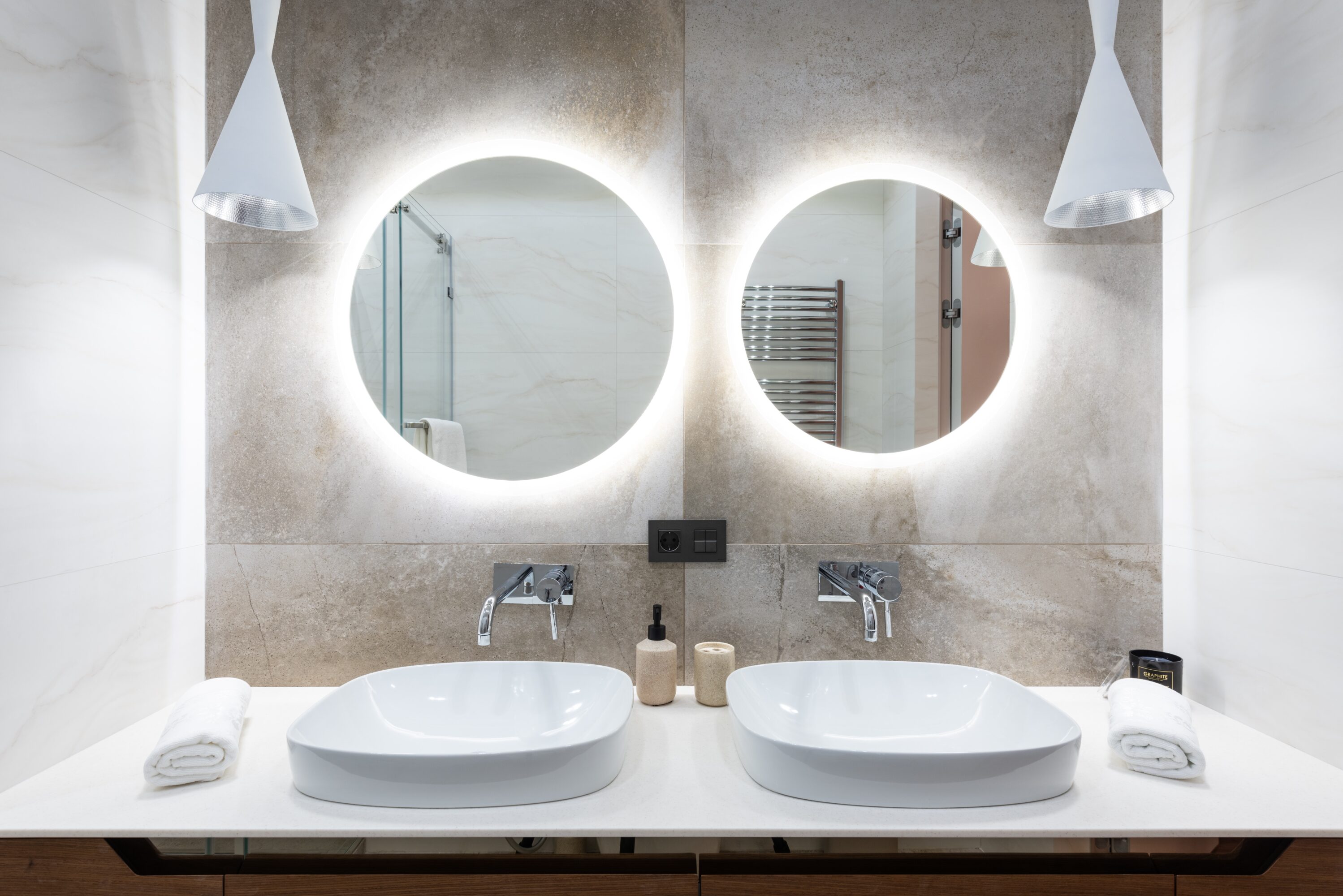 A beautiful, newly-remodeled bathroom with two sinks and two round mirrors