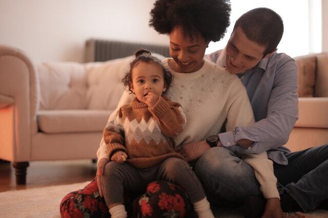 a young family with a small baby girl on the mother's lap