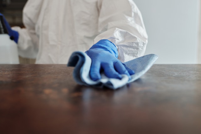 a man in a protective suit cleaning a table