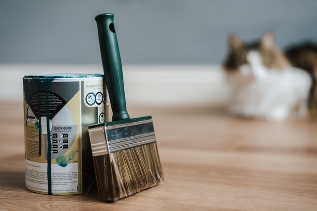 a can of green paint and a brush
