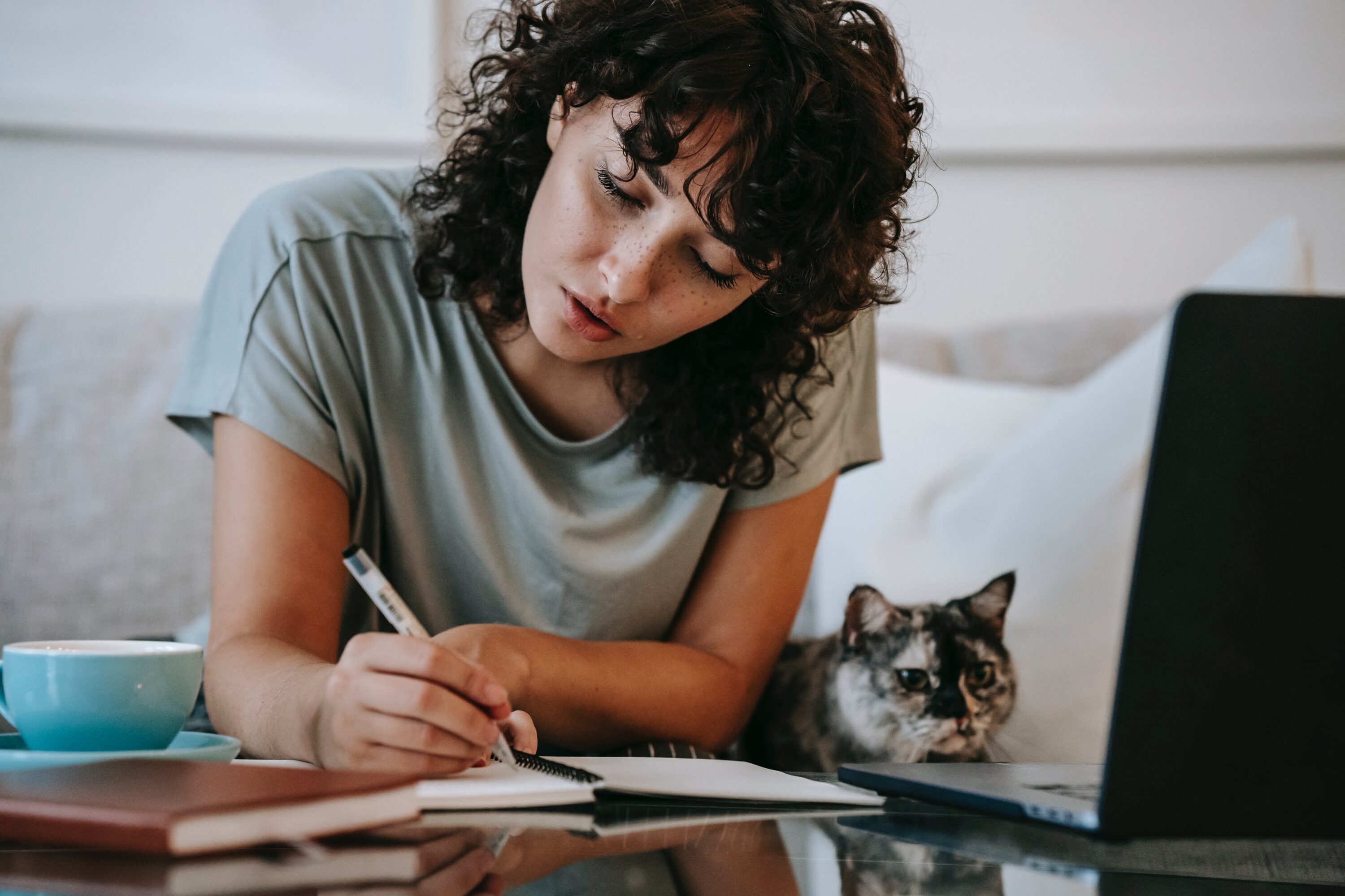 Girl writing with a cat
